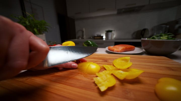 Slicing Peppers With Precision In A Cozy Kitchen