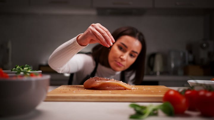 Home Chef Sprinkles Spice on Fresh Chicken Breast