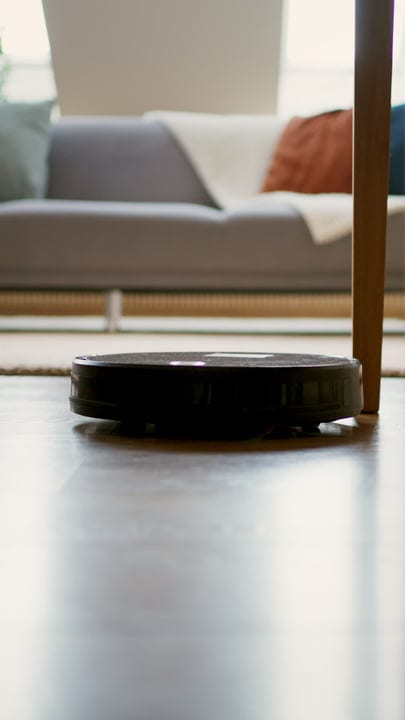 Smart Vacuum Glides Over Sunlit Living Room Floor