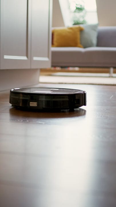 A Robot Vacuum Glides Across a Cozy Living Room Floor