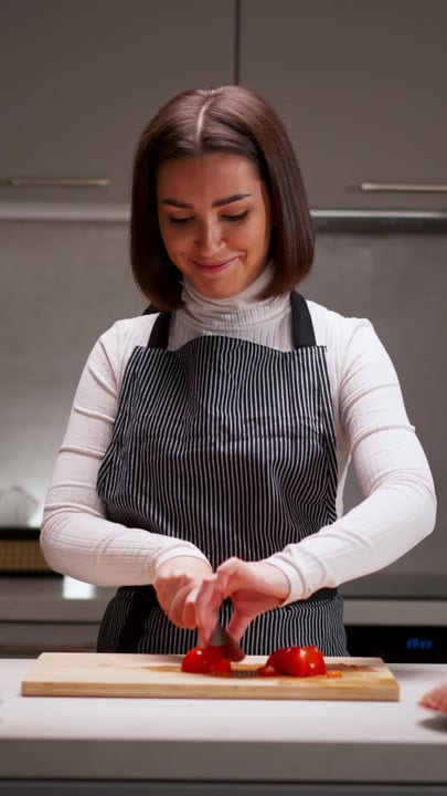 A Woman Chops Tomatoes in a Cozy Kitchen