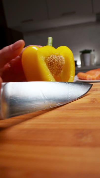 Close-Up of a Knife Slicing a Yellow Bell Pepper