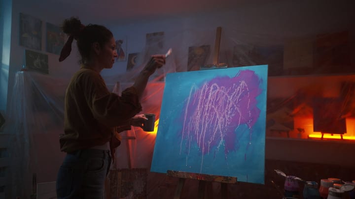 A Painter Immersed In Creative Expression Under Soft Light