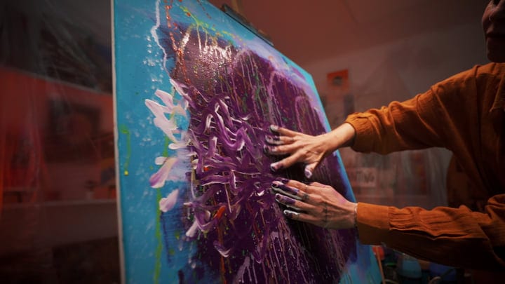 Artist's Hands Dance Across Canvas In Studio Light