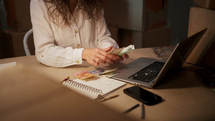 Counting Euros in a Sunlit Artist's Studio Workspace