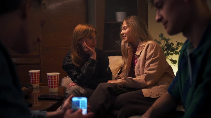 Friends Share Laughter In Warm Living Room
