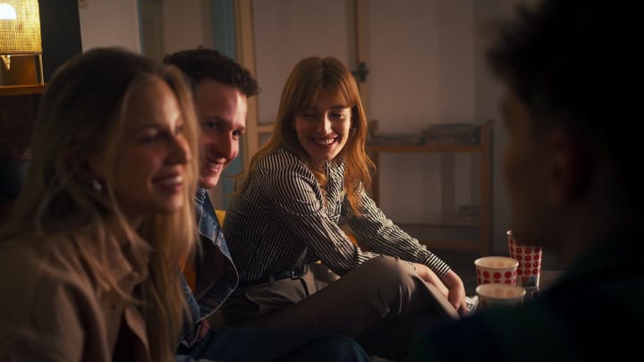 Laughing Friends Relaxing Together In Warm Indoor Setting