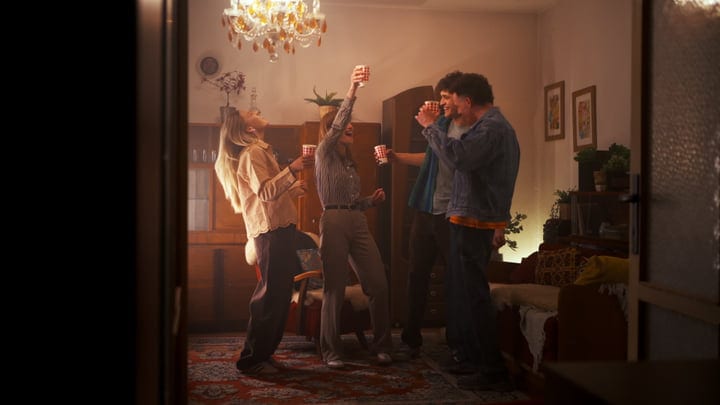Laughter and Toasts Amidst Warm Evening Glow Indoors