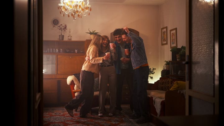 Friends Share Laughter Under Warm Chandelier Light