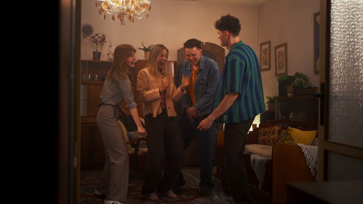 Laughter Under A Chandelier At Cozy Friends Gathering