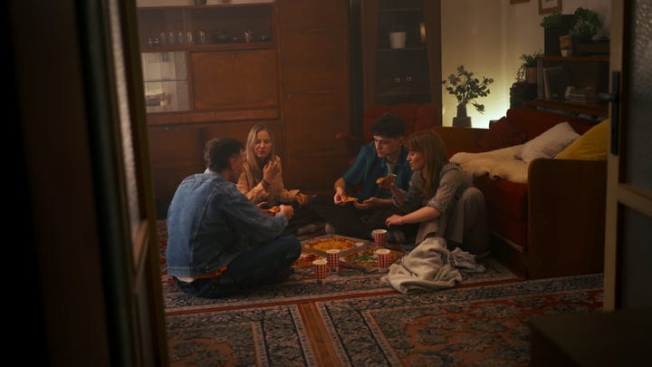 Young Friends Sharing Pizza In A Cozy Living Room