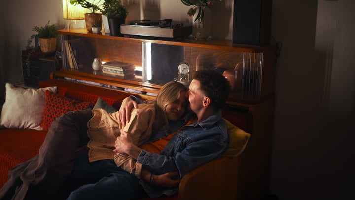 Couple Embraces Warmly In A Cozy Living Room