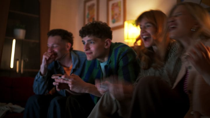 Friends Share Laughter Over an Evening Game Session