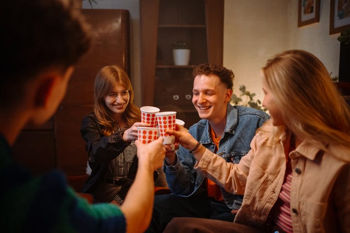 Friends Share Laughter And Warmth Over Drinks