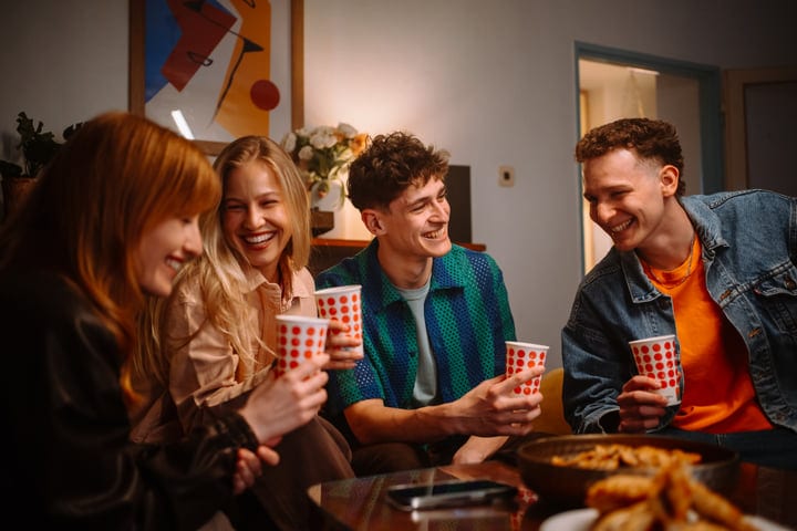 Laughter and Warmth Over Shared Drinks in Cozy Setting