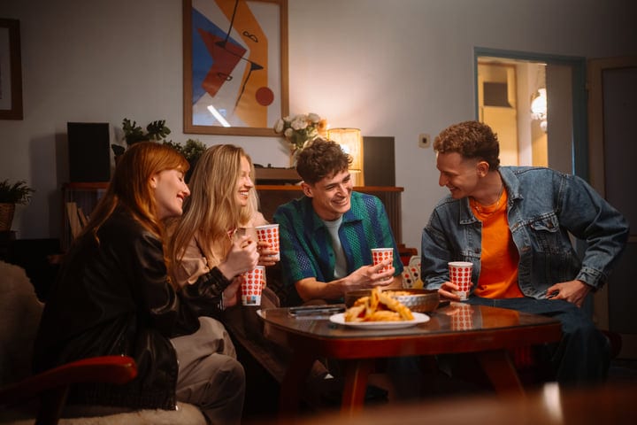 Joyful Laughter and Warm Drinks in a Cozy Living Room