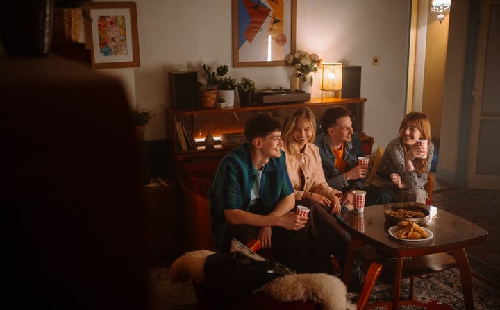 Friends Sharing Laughter Over Warm Drinks Indoors