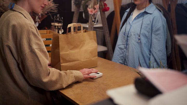 A Friendly Exchange At The Boutique Checkout Counter