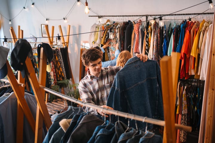Young Friends Explore Colorful Racks In Trendy Boutique