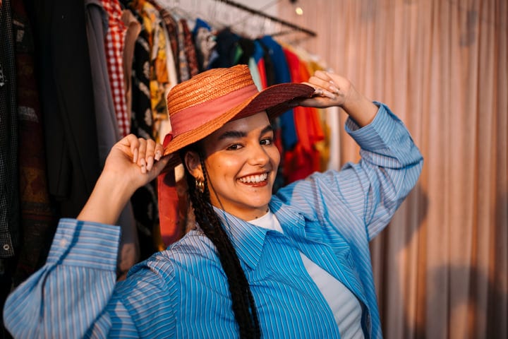 Joyful Moment Trying On Hats In A Cozy Boutique