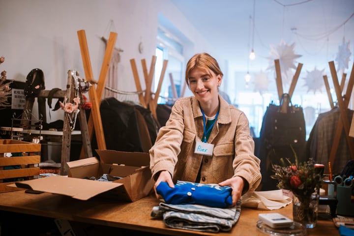 A Boutique Employee Prepares Clothes For Display With Care