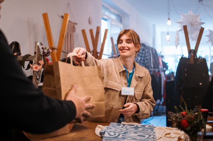 A Warm Exchange Between Friends In A Cozy Boutique