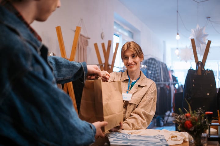 Friendly Exchange Over the Boutique Counter, Smiles Abound