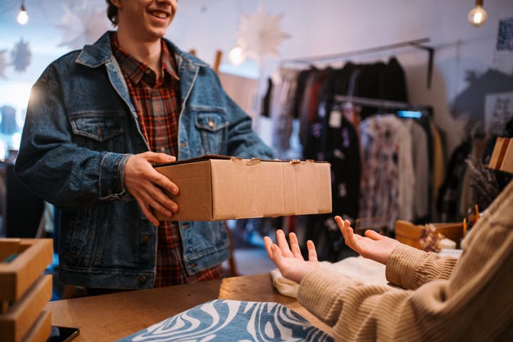 Joyful Exchange Of Packages In A Cozy Boutique Setting