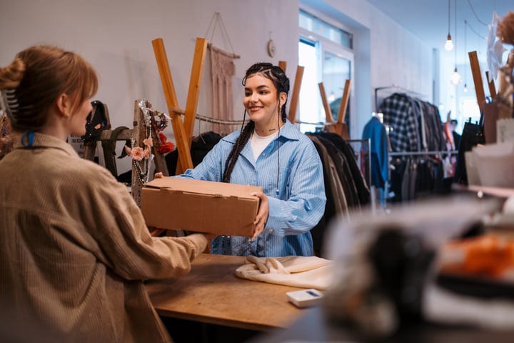 Joyful Exchange Of A Gift In A Cozy Boutique