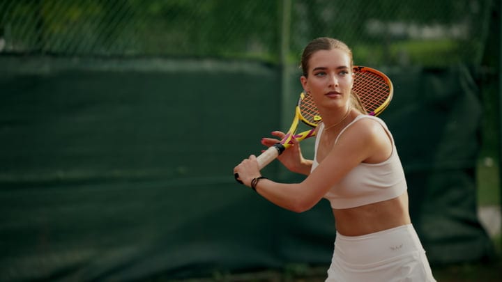 Focused Tennis Player Prepares For A Powerful Serve