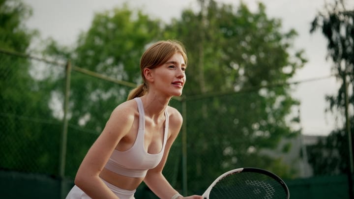 Focused Tennis Player Prepares for a Powerful Serve