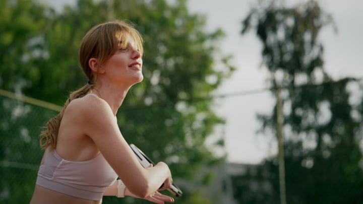 A Tennis Player Prepares To Serve Under Summer Skies