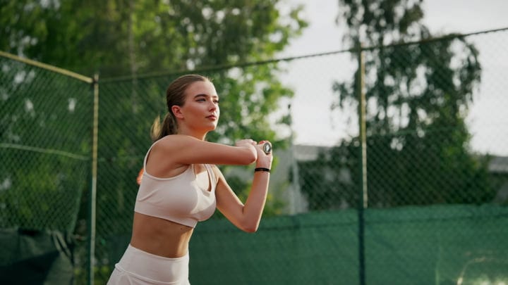 Focused Tennis Player Prepares to Strike Under Summer Sky