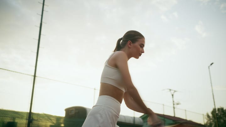 Young Woman Athlete Hitting Forehand Stroke On An Outdoor Tennis Court