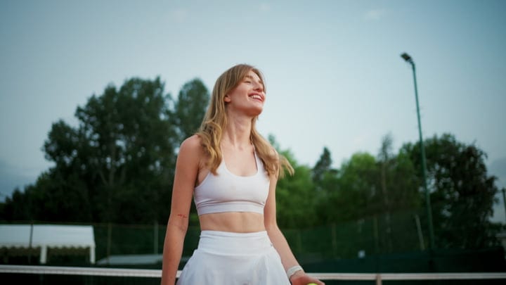 Joyful Tennis Player Embraces The Game On Sunny Court