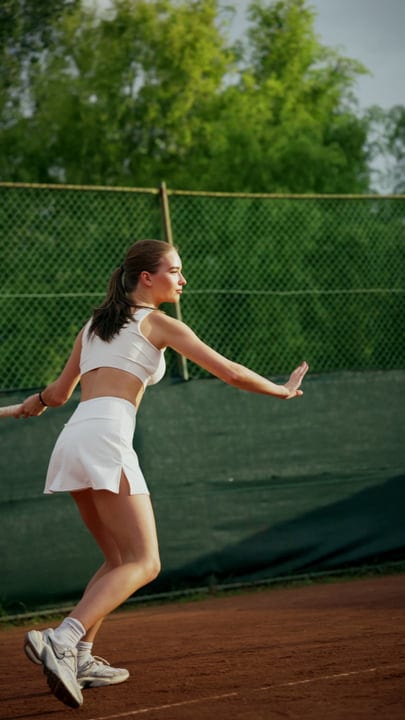 Determined Young Woman Makes A Serve On A Red Clay Court