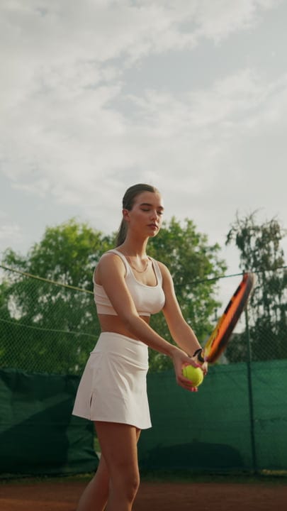 Young Woman Tennis Player Prepares Serve On Outdoor Clay Court