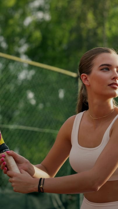 Athletic Young Woman Holding Tennis Racket On A Sunny Outdoor Clay Court