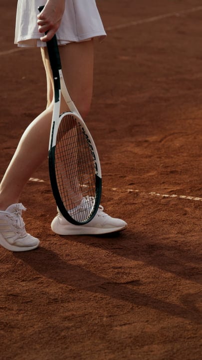 Tennis Player Standing On Clay Court With Racket, Ready To Serve