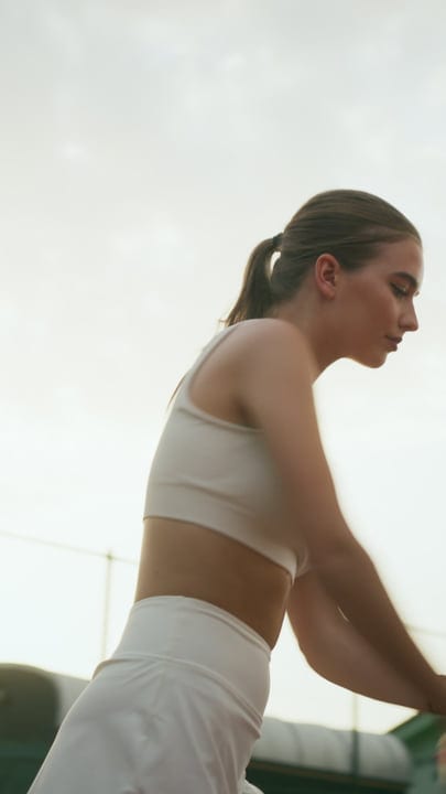 Focused Female Tennis Player Preparing to Hit a Serve on a Bright Outdoor Court
