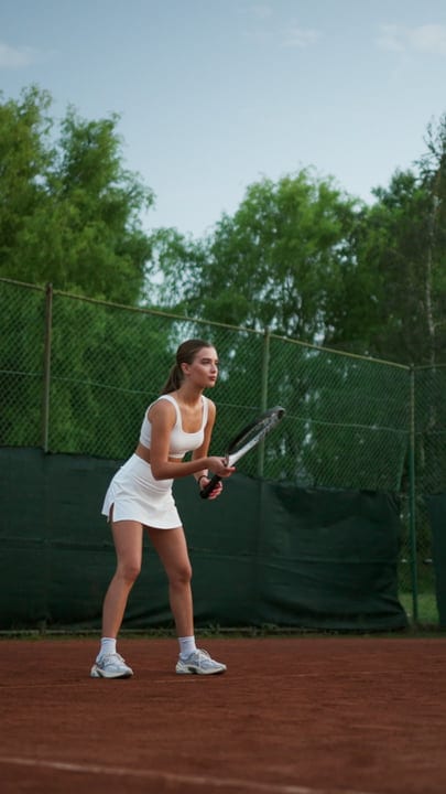 Focused Female Tennis Player Ready To Serve On Outdoor Clay Court