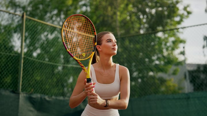 Female Tennis Player Looking Up While Preparing For A Serve