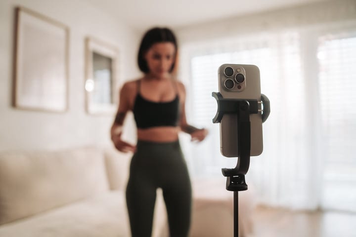 Fitness Enthusiast Recording Her Daily Home Workout With A Smartphone