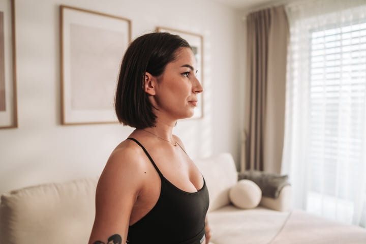 Young Woman In Black Top Looks Right In Bright Modern Room
