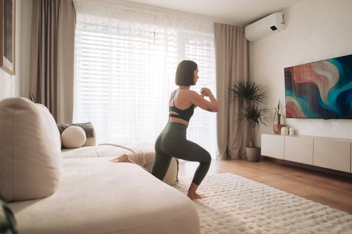 Woman Performs Lunges In Her Modern Sunlit Living Room