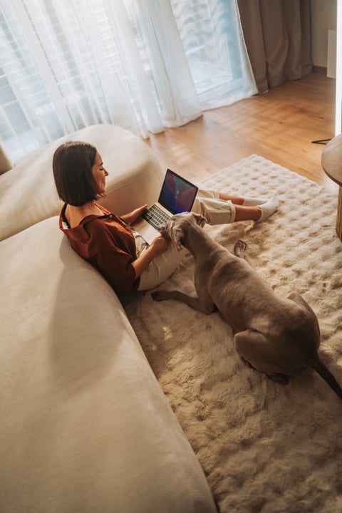 Woman Enjoying Her Morning Routine Working On Laptop With Dog