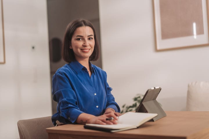 Young European Woman Smiles At Camera While Planning Her Day Indoors