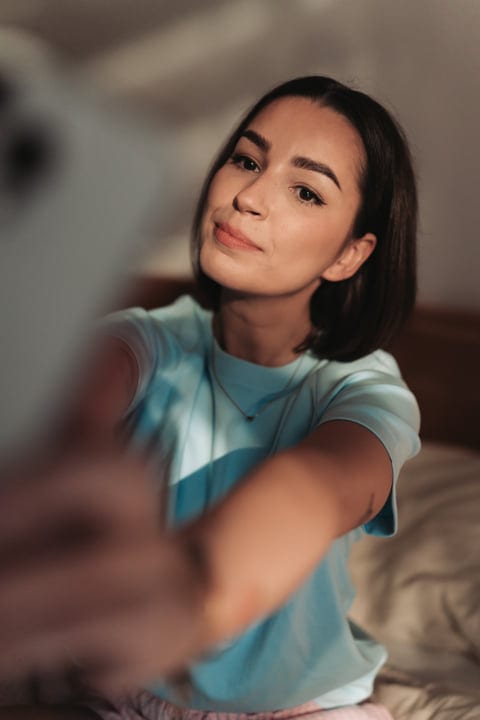 Young Woman Posing For A Selfie In Her Bedroom In The Morning