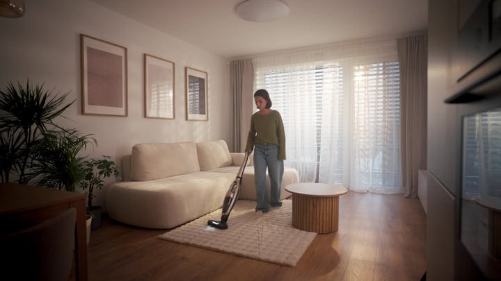 Woman Vacuuming Light Rug In Modern Living Room Apartment Morning