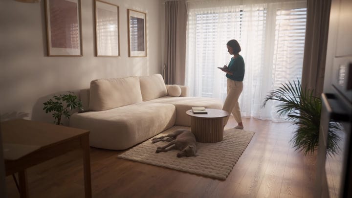 Woman Standing And Writing On Digital Tablet In Sunny Living Room